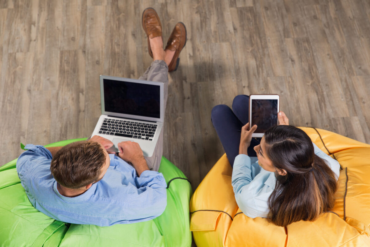 Man and Woman Working on Laptop and Tablet in Cafe Boekhouder ZZP'er zorg